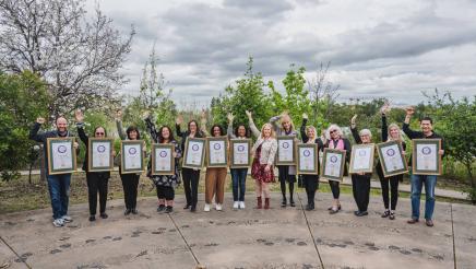 Group picture of Women of the Year with raised hands